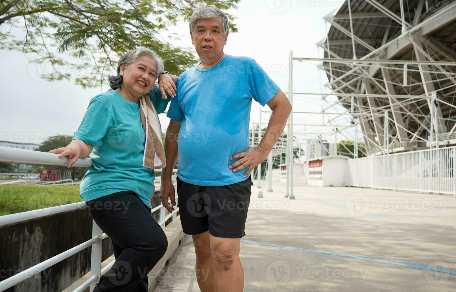 content et sourire des couples personnes âgées asiatique permanent sur escaliers pour du repos après entraînement, le jogging sur matin, Sénior exercice Extérieur pour bien en bonne santé. concept de soins de santé et actif mode de vie pour en bonne santé photo