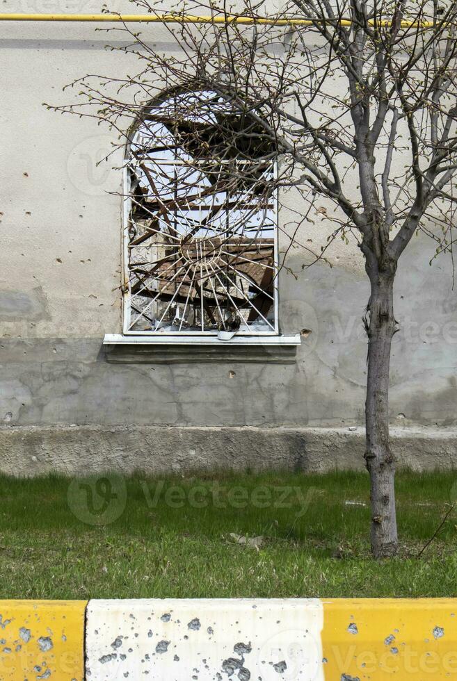 détruit et endommagé fenêtre dans le bâtiment comme une résultat de le guerre. le Maisons étaient détruit et brûlé par artillerie pendant le guerre. cassé les fenêtres. une fenêtre détruit par le lutte. photo