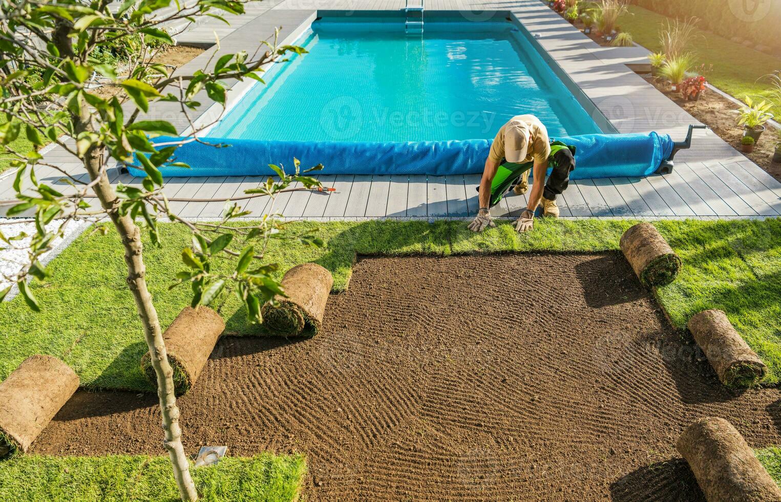 jardinier installation rouleau en dehors pelouse suivant à bassin photo