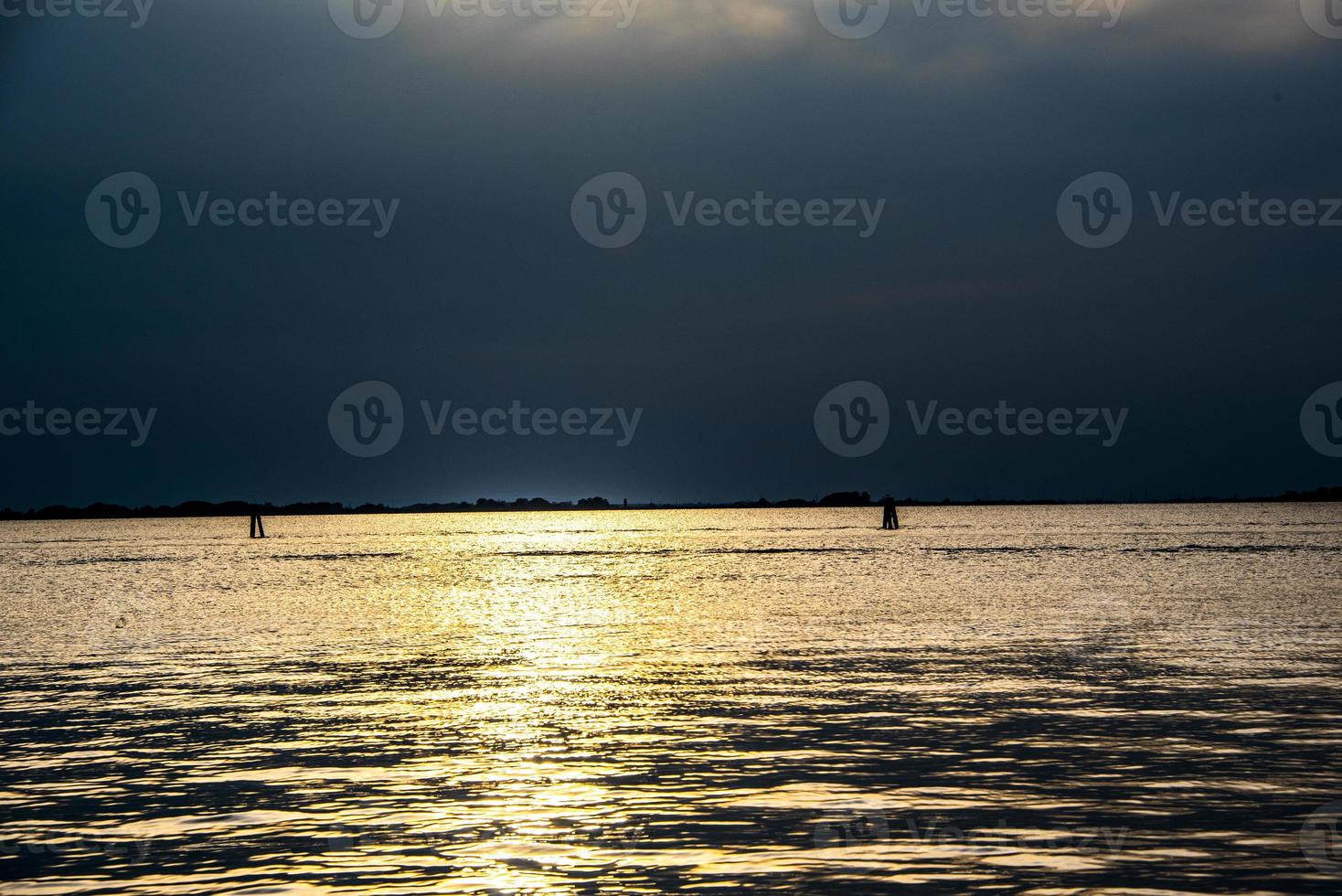 Coucher de soleil sur la lagune de Venise, Italie avec des reflets dorés sur la mer photo