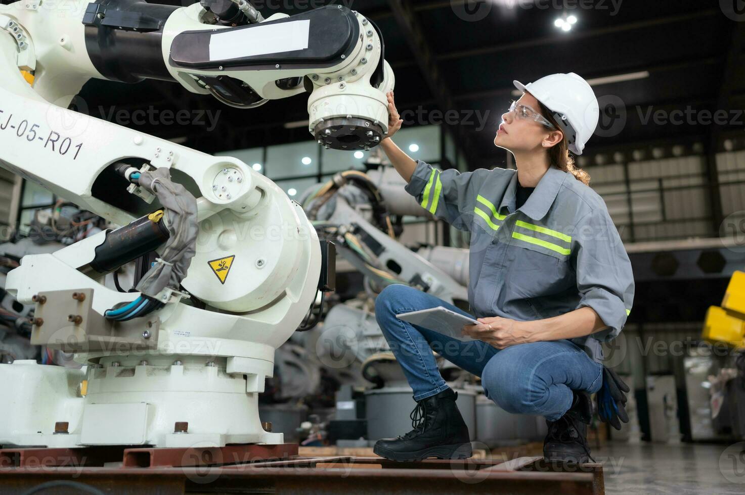 une femelle ingénieur installe une programme sur une la robotique bras dans une robot entrepôt. et tester le opération avant Envoi en cours le machine à le client. photo