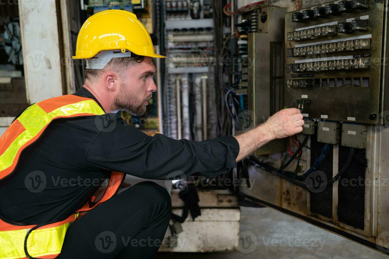 le ingénieur inspecte le électrique système et réparations le mécanique système dans le machine contrôle armoire. dans commande pour le machine à revenir à Ordinaire opération photo