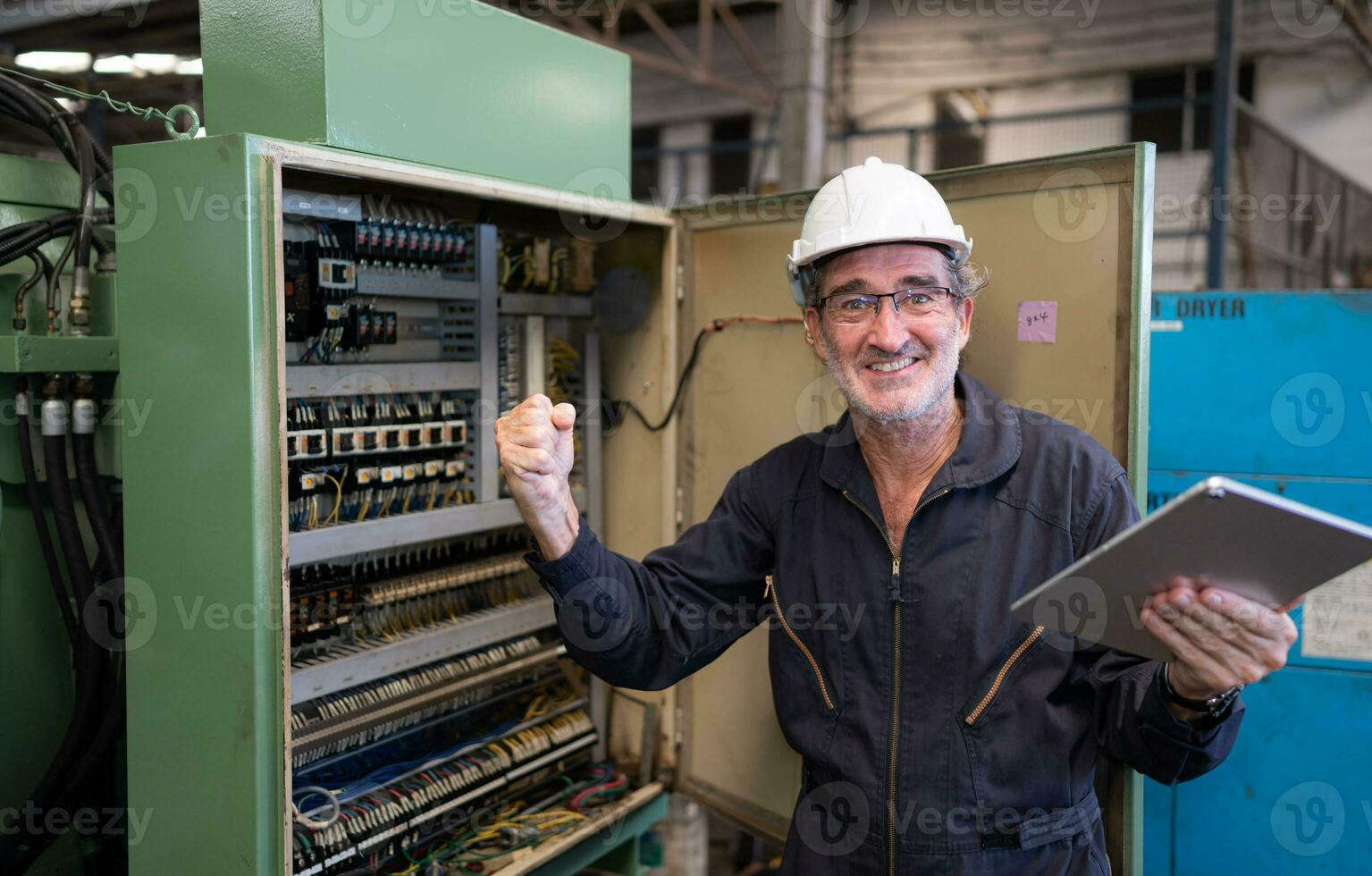 Sénior ingénieur inspecte le électrique système et réparations le mécanique système dans le machine contrôle armoire. dans commande pour le machine à revenir à Ordinaire opération photo