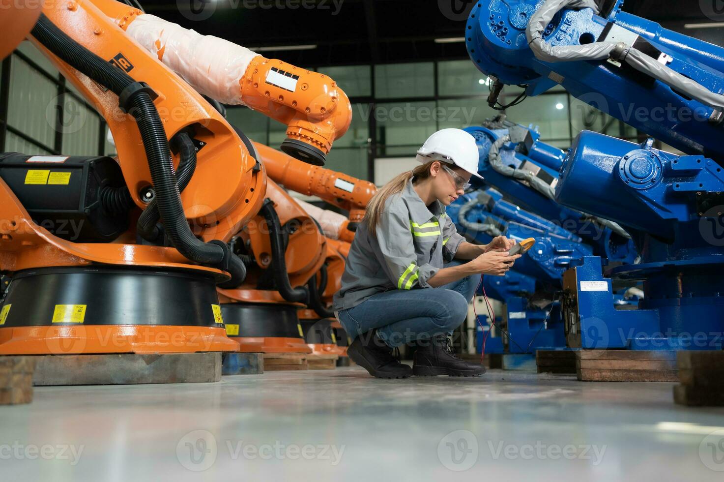 dans le des robots entrepôt, une femelle ingénieur inspecte le électrique système de chaque la robotique bras, avant livrer à le client. photo
