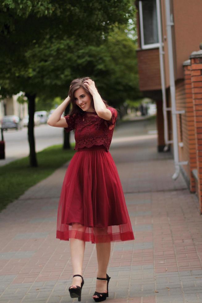 fille marchant dans la rue en robe rouge photo