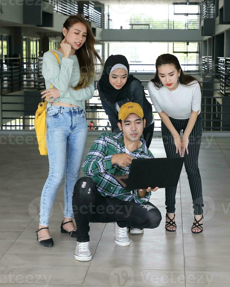 Jeune asiatique malais chinois homme femme intérieur escalier couloir Campus livre fichier dossier portable ordinateur téléphone asseoir supporter étude mêler photo
