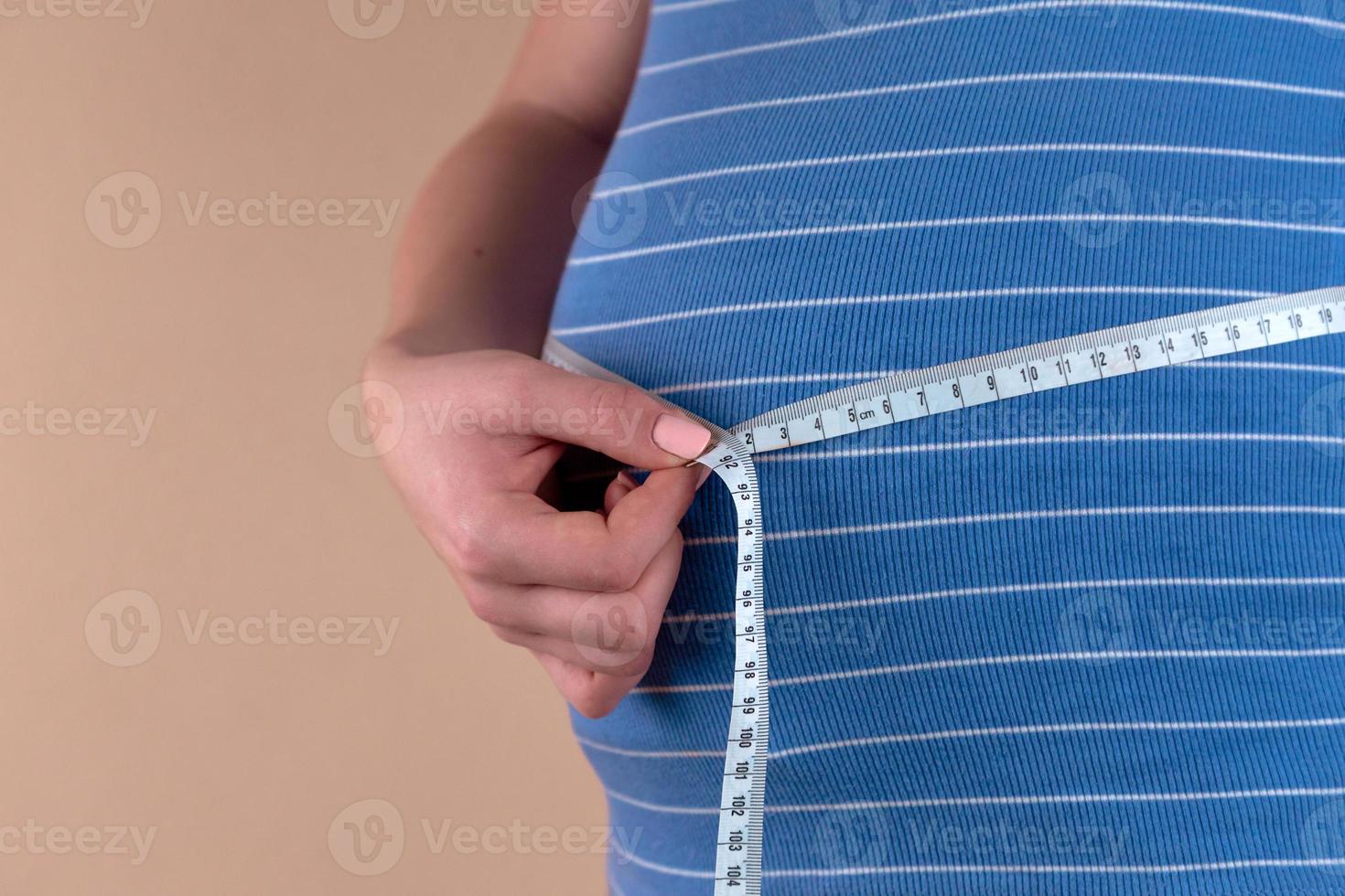 beau corps de femme enceinte avec ruban à mesurer photo