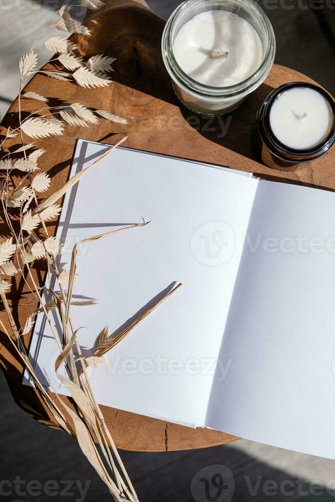 magazine et livre maquette conception. Vide magazine sur moderne en bois table avec bougies , ombre recouvrir photo