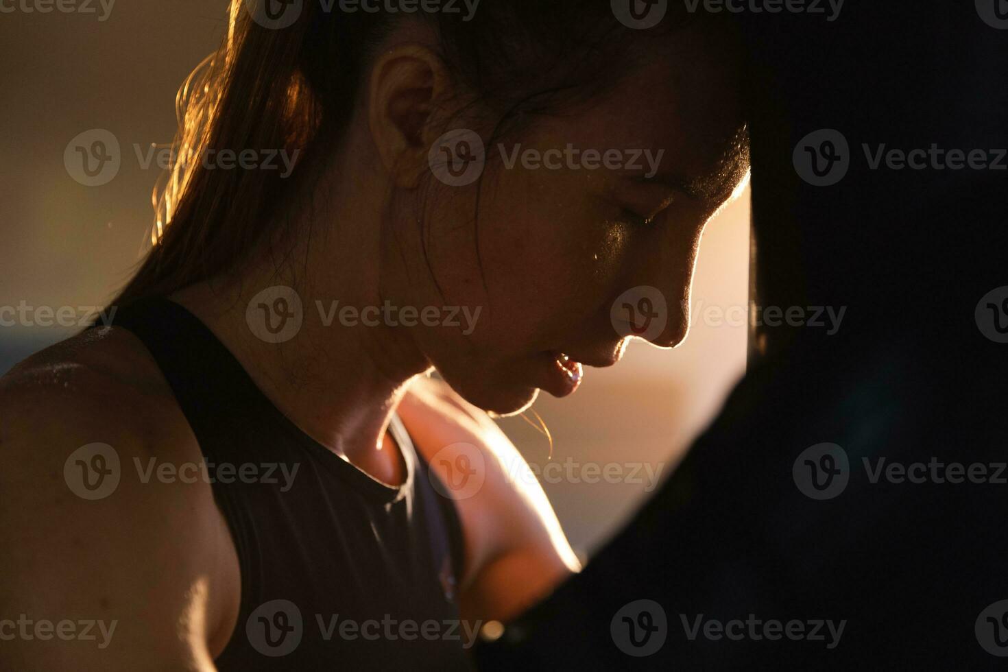 femmes soi la défense fille pouvoir. fort femme combattant repos après bats toi formation sur boxe anneau. fort fille fatigué après perforation boxe sac. formation journée dans salle de sport. force en forme corps faire des exercices entraînement. photo