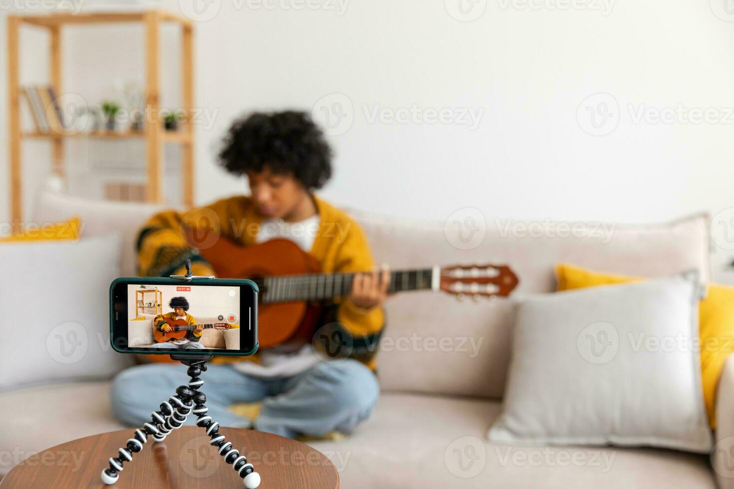 blogueur guitariste. content africain américain fille blogueur en jouant guitare en chantant chanson enregistrement vlog. social médias influenceur femme diffusion enregistrement à Accueil studio. la musique contenu créateur diffuser. photo