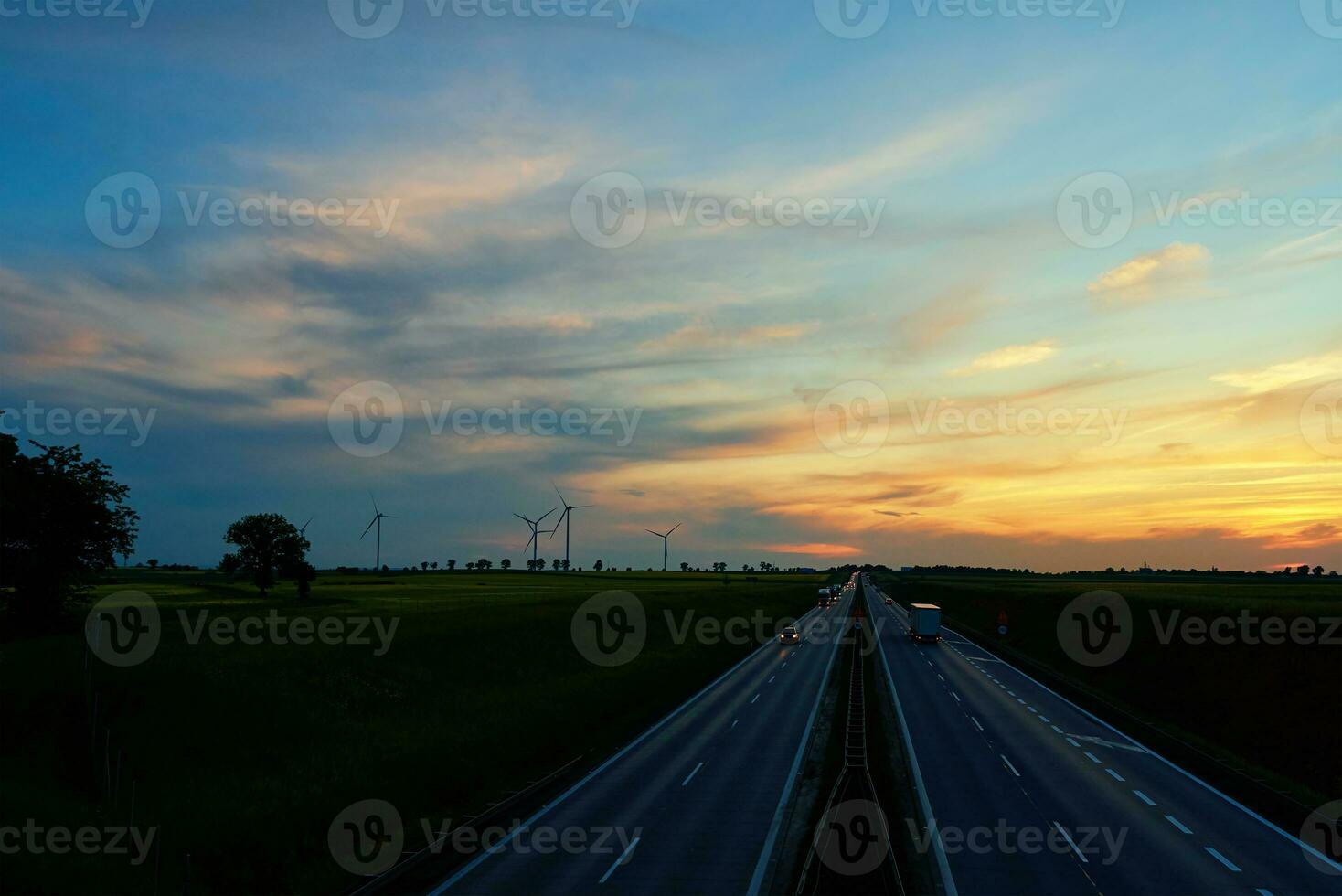 Autoroute avec voiture circulation et Moulin à vent turbines à le coucher du soleil photo