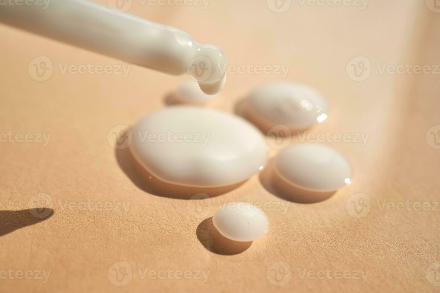 gouttes de blanc produits de beauté sur une beige Contexte. photo