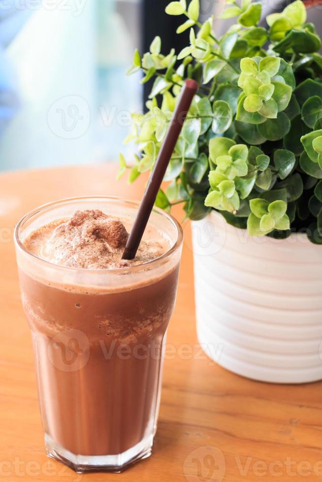 Milk-shake au cacao sur table en bois avec plante artificielle photo