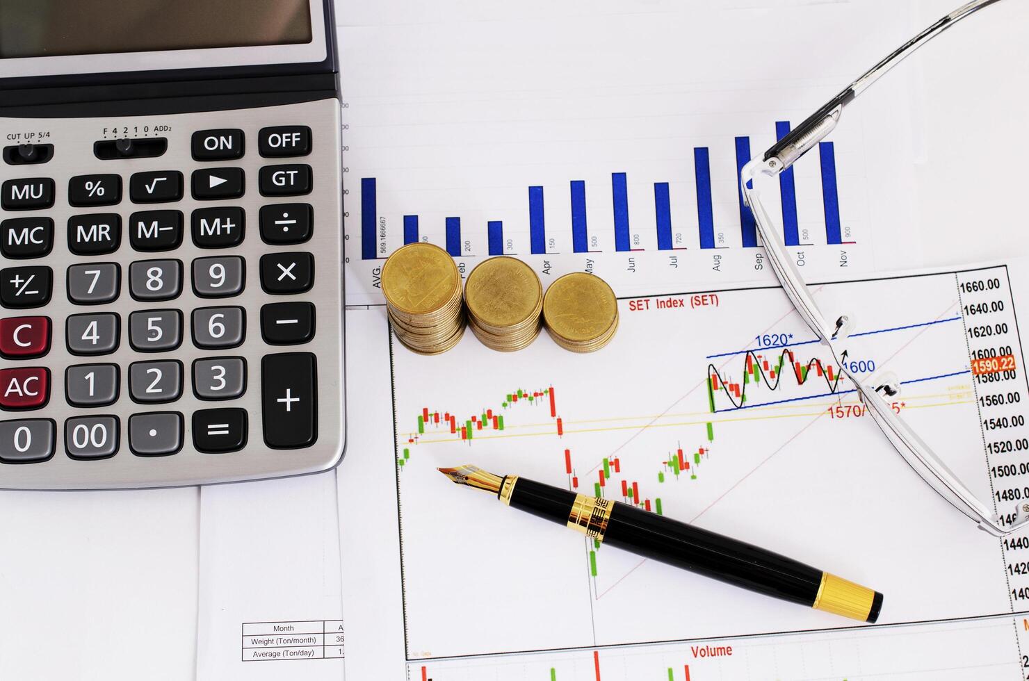 stylo-plume d'affaires et pile de pièces de monnaie et lunettes et calculatrice pour le concept de l'investisseur en stock photo