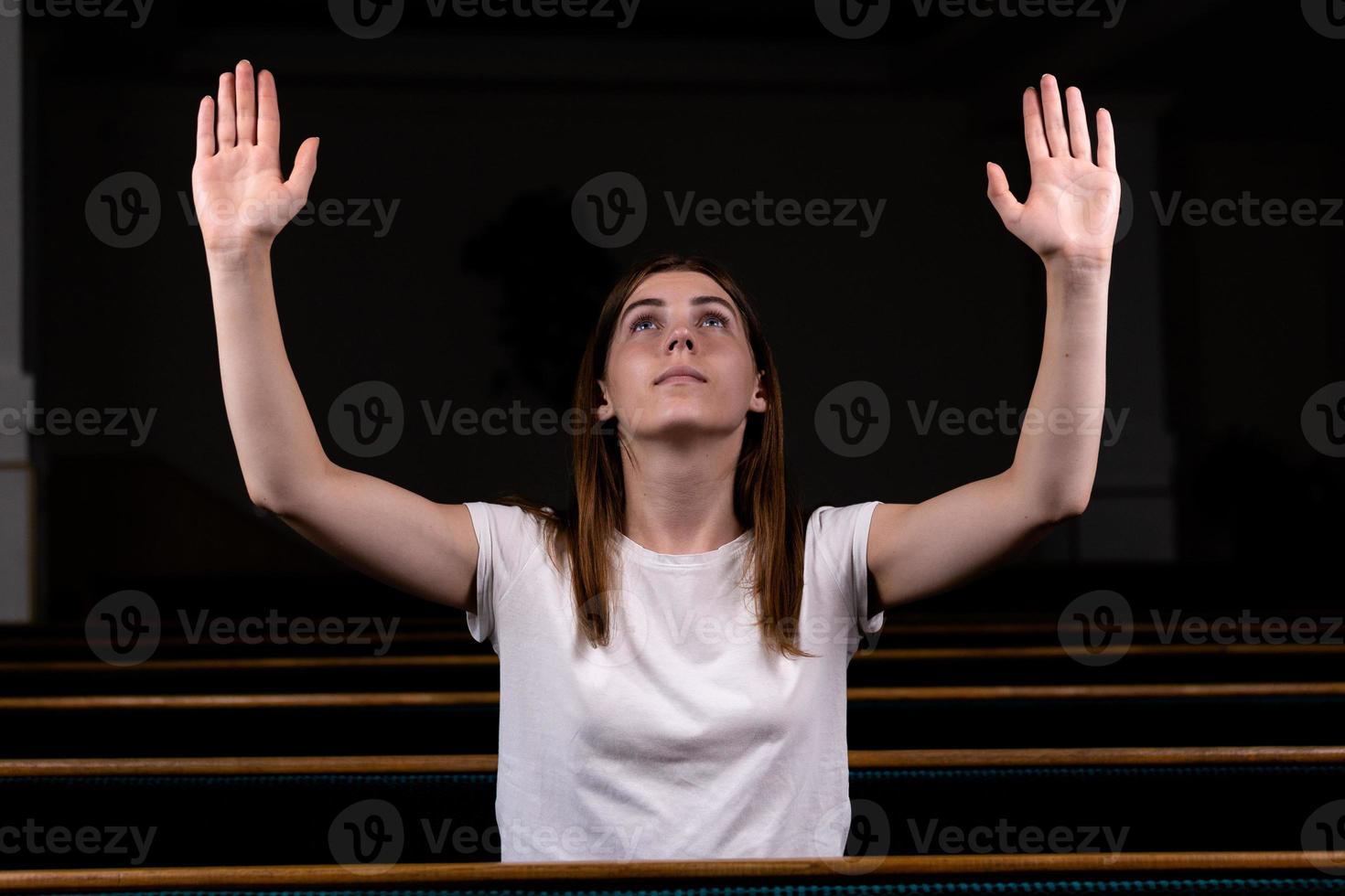 une fille chrétienne en chemise blanche prie avec un cœur humble dans l'église photo