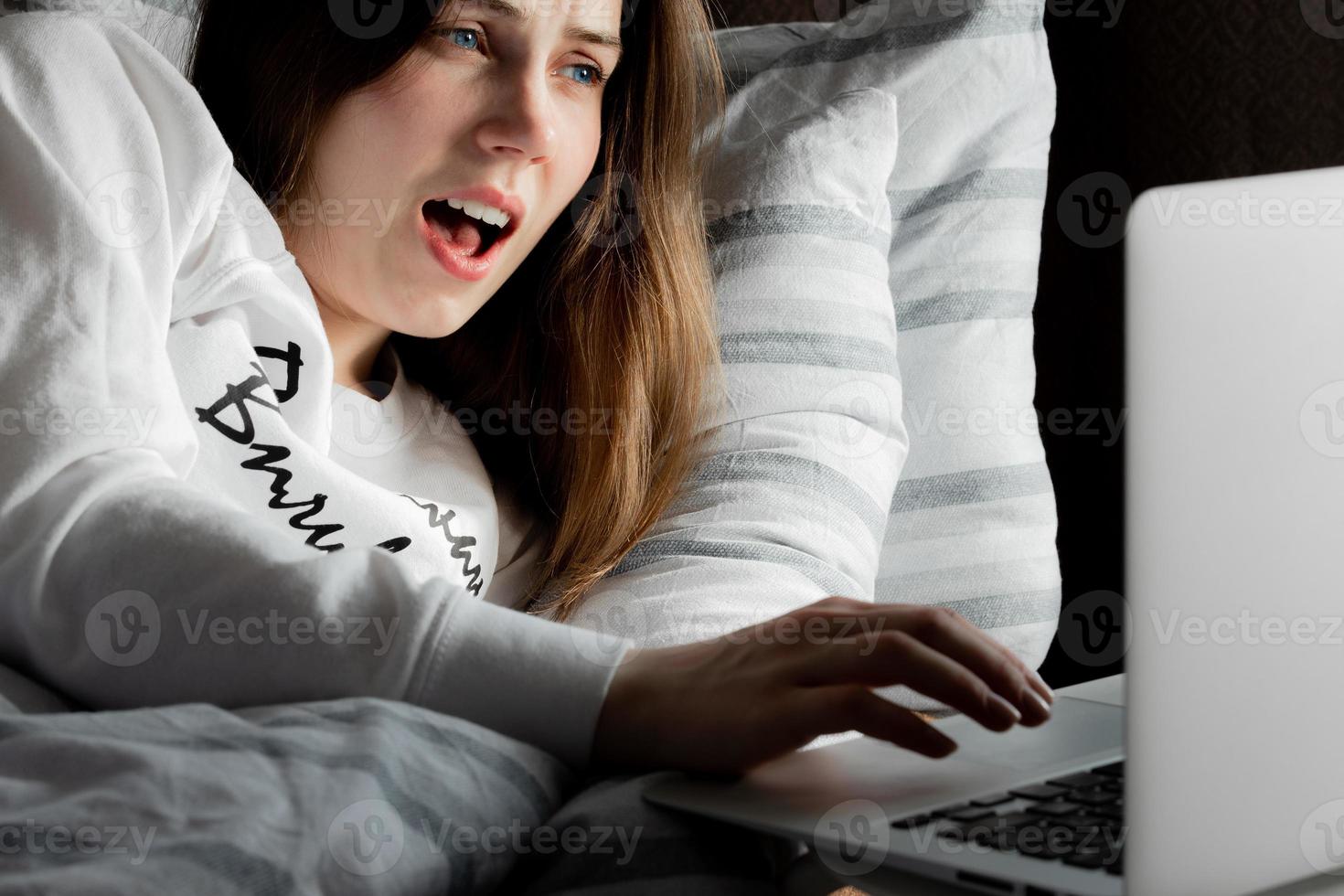 jeune fille mignonne sur une journée ensoleillée regardant un ordinateur portable dans la surprise photo