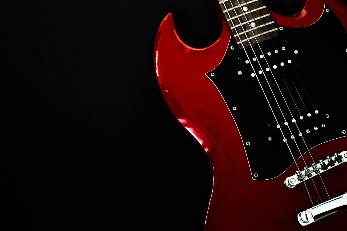 Gros plan de guitare électrique rouge sur fond noir photo