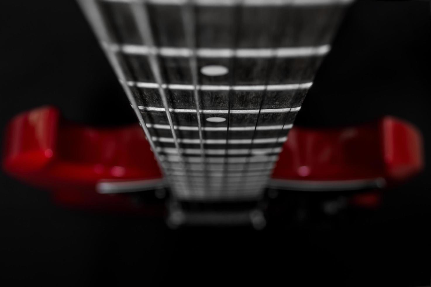 Gros plan de guitare électrique rouge sur fond noir photo