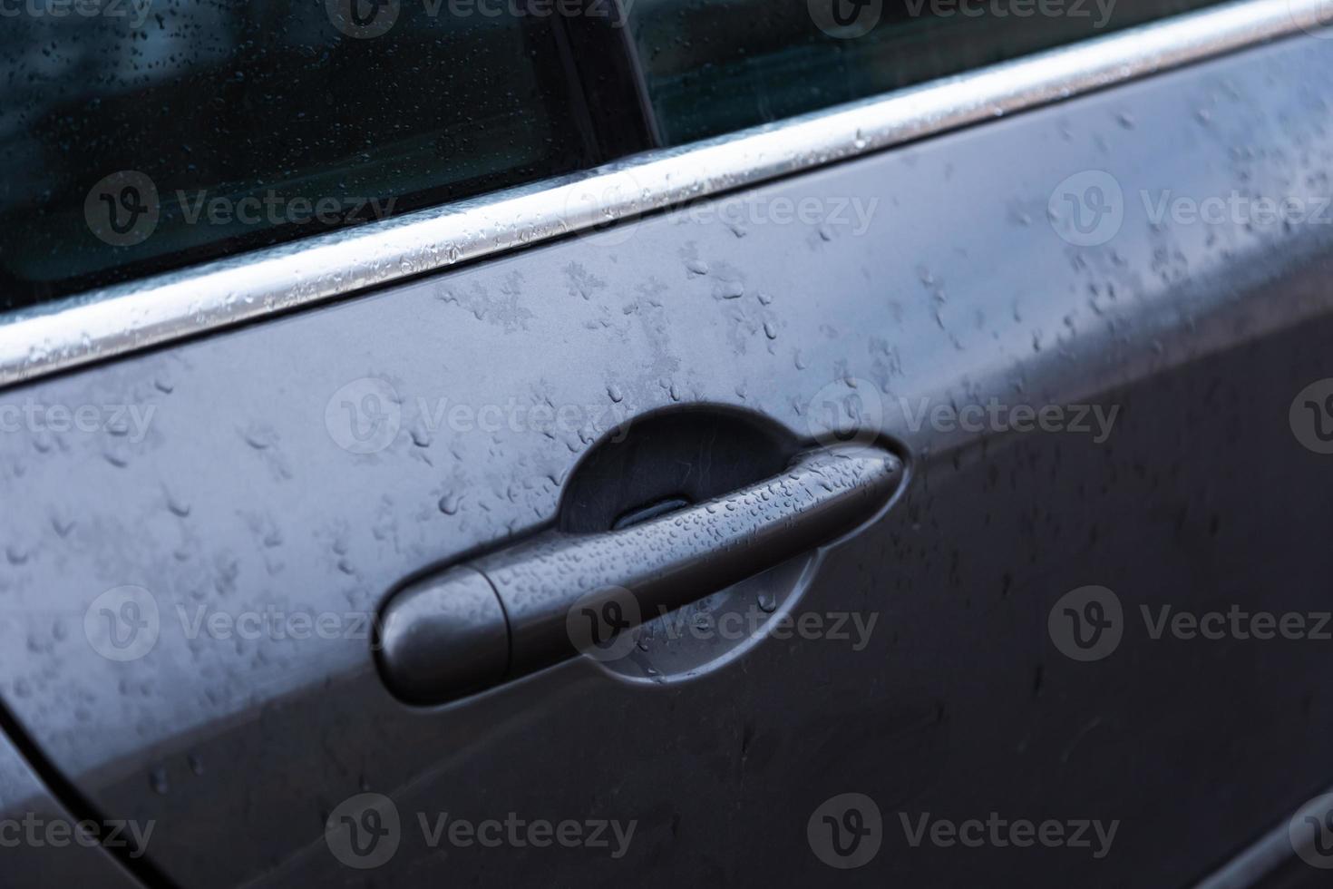 poignée de porte de voiture avec gouttelettes d'eau ou de pluie photo