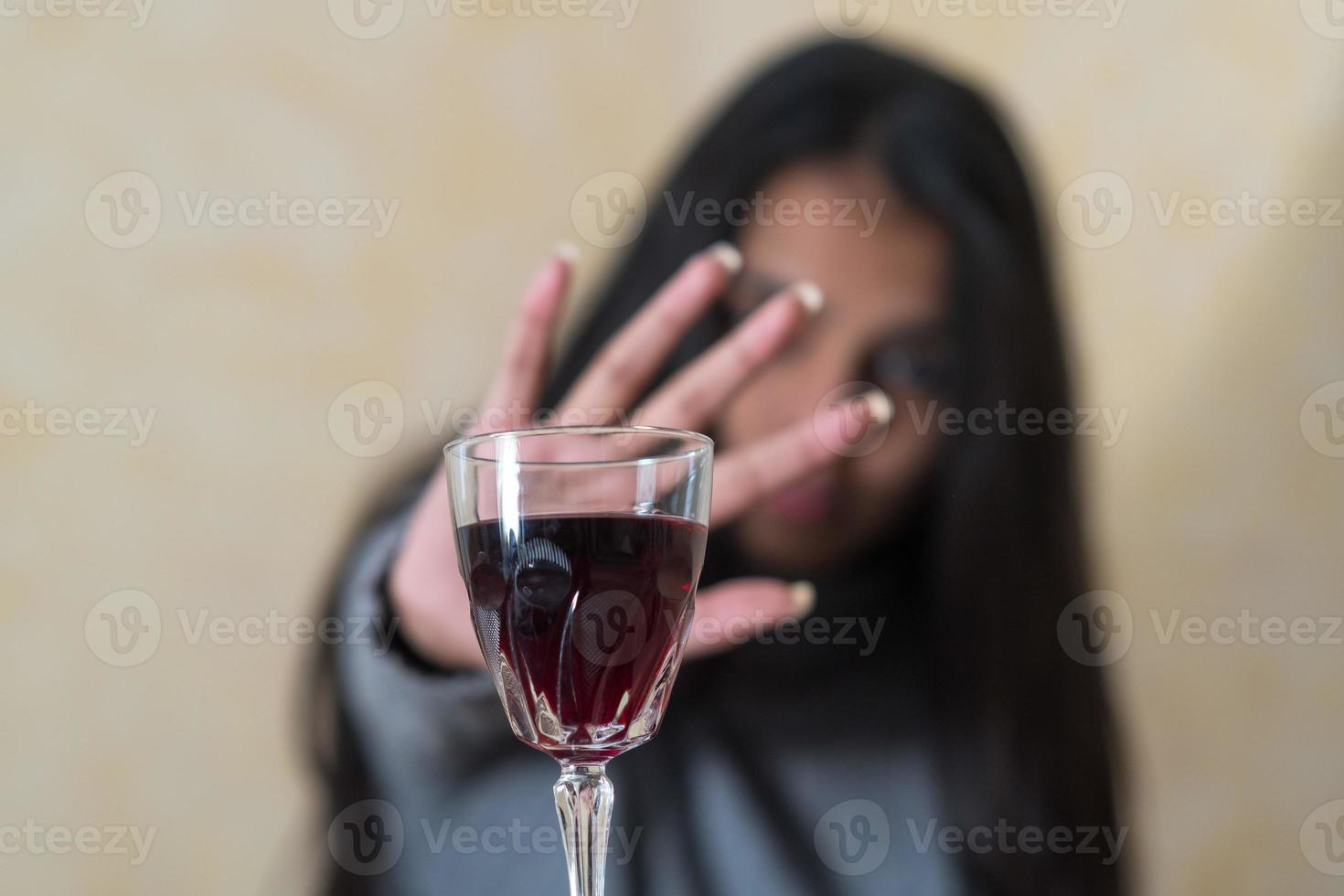 abandonner l'alcool une jeune femme à table refuse un verre de vin rouge avec sa main photo