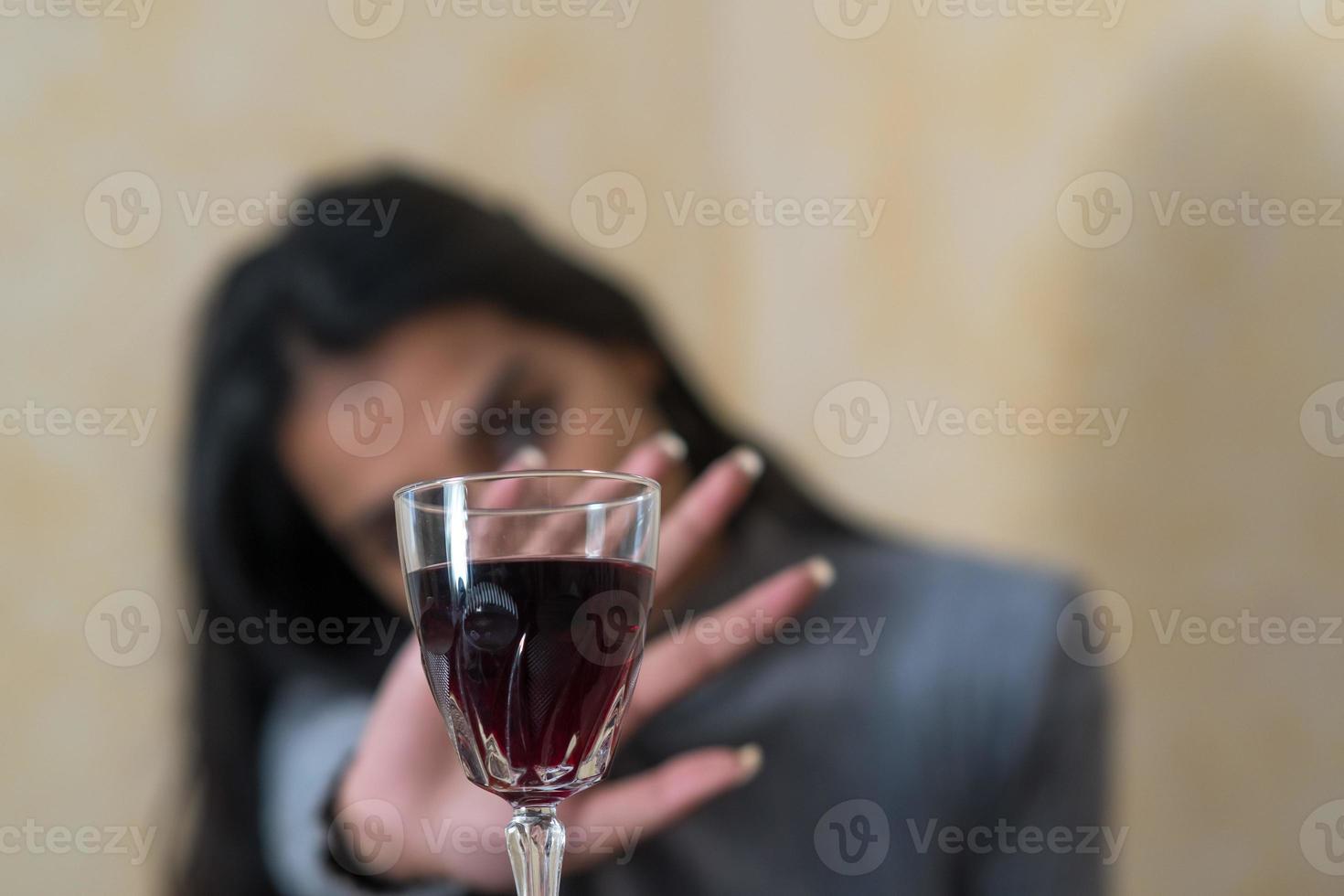 abandonner l'alcool une jeune femme à table refuse un verre de vin rouge avec sa main photo