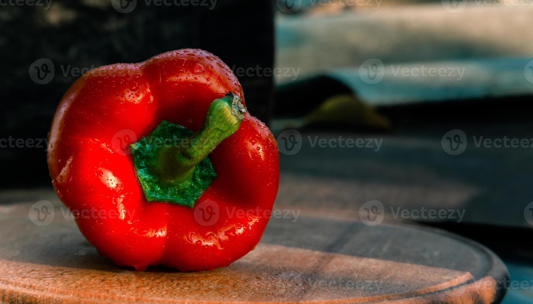 Un poivron rouge frais bouchent sur fond de bois photo