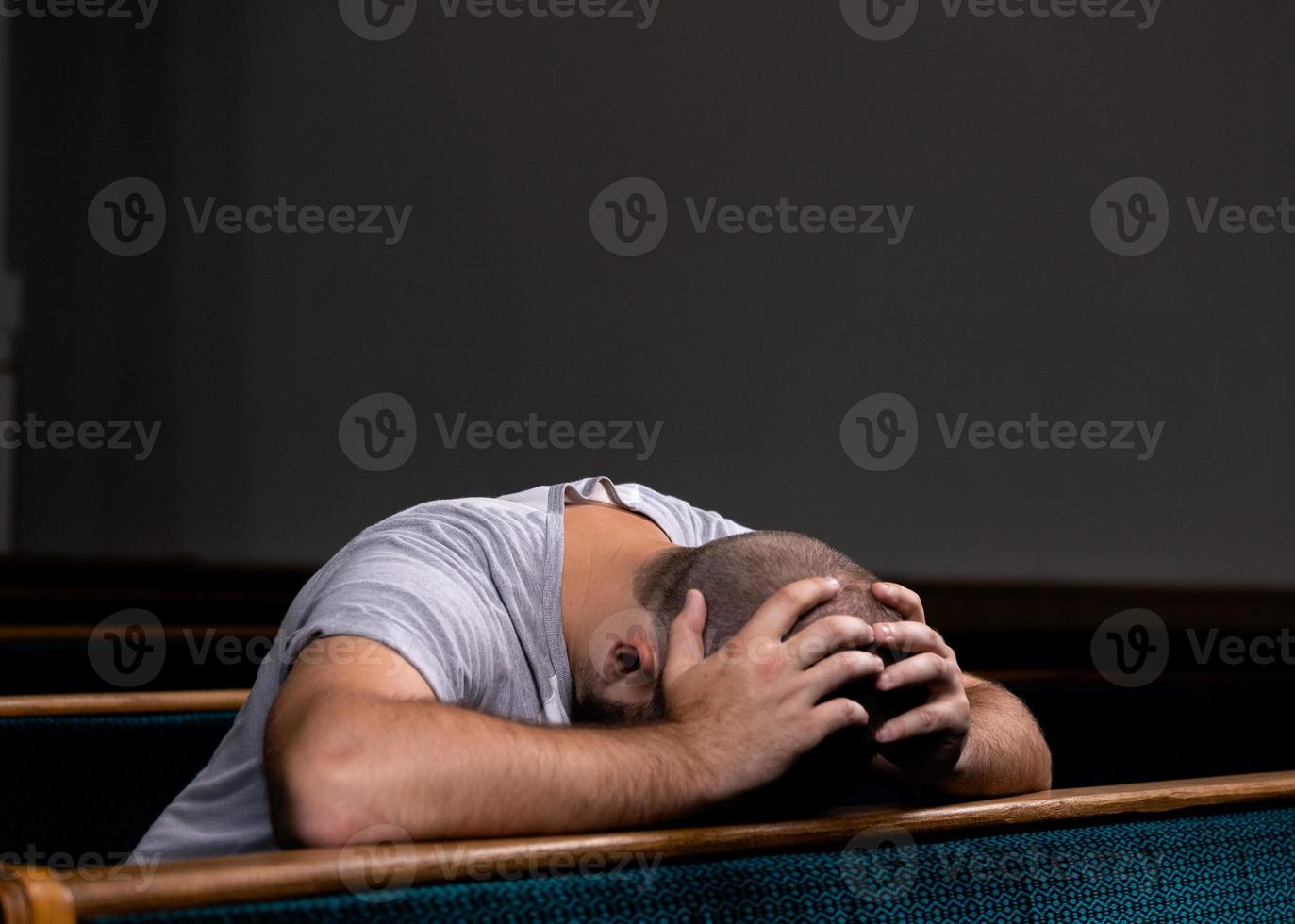 Un triste homme chrétien en chemise blanche est assis et prie avec un cœur humble dans l'église photo