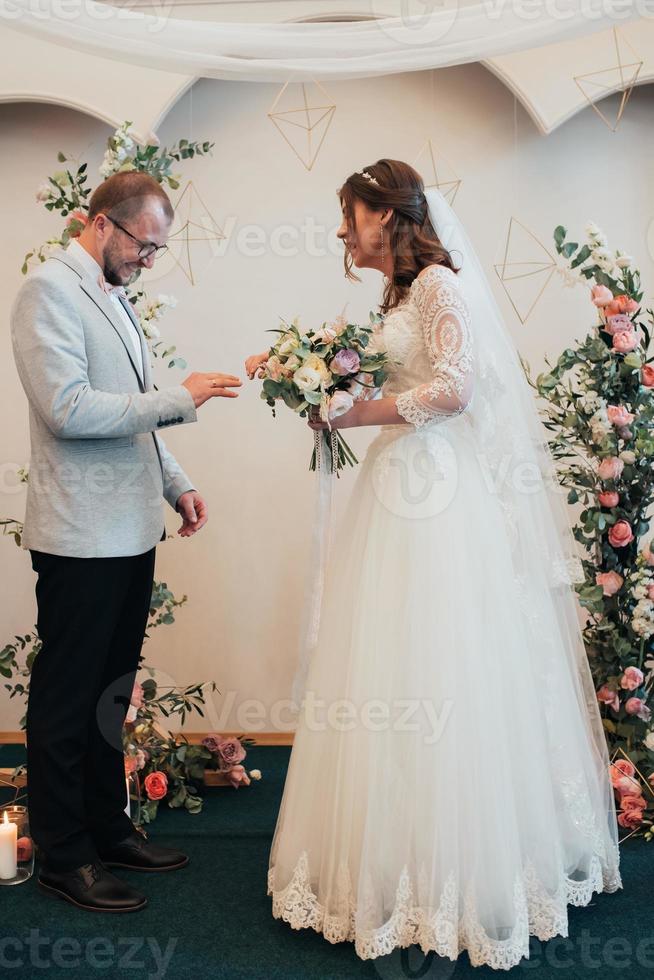 les mariés échangent des bagues en or de mariage photo