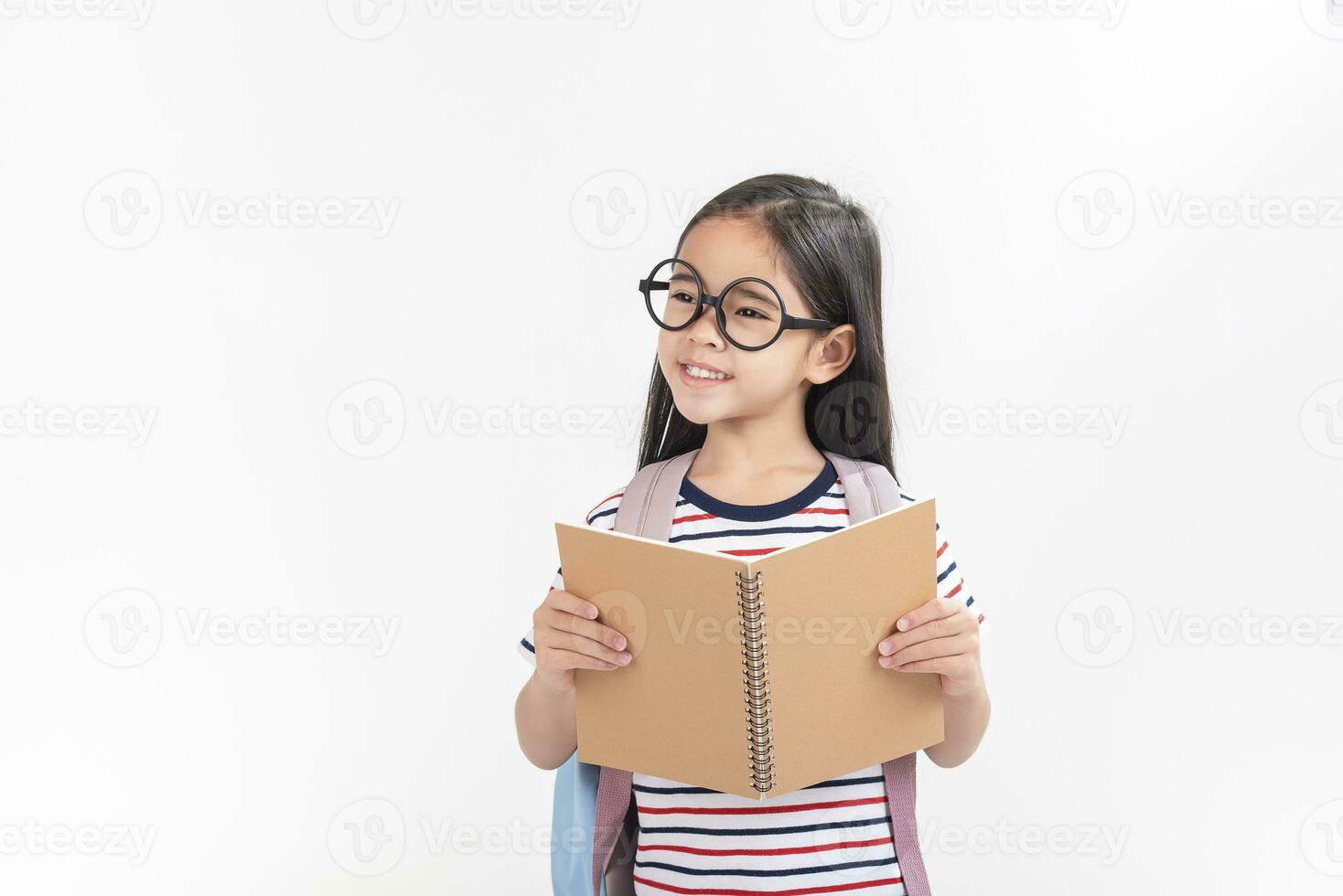 écolière étreindre livre portant sac à dos souriant isolé sur blanc Contexte photo