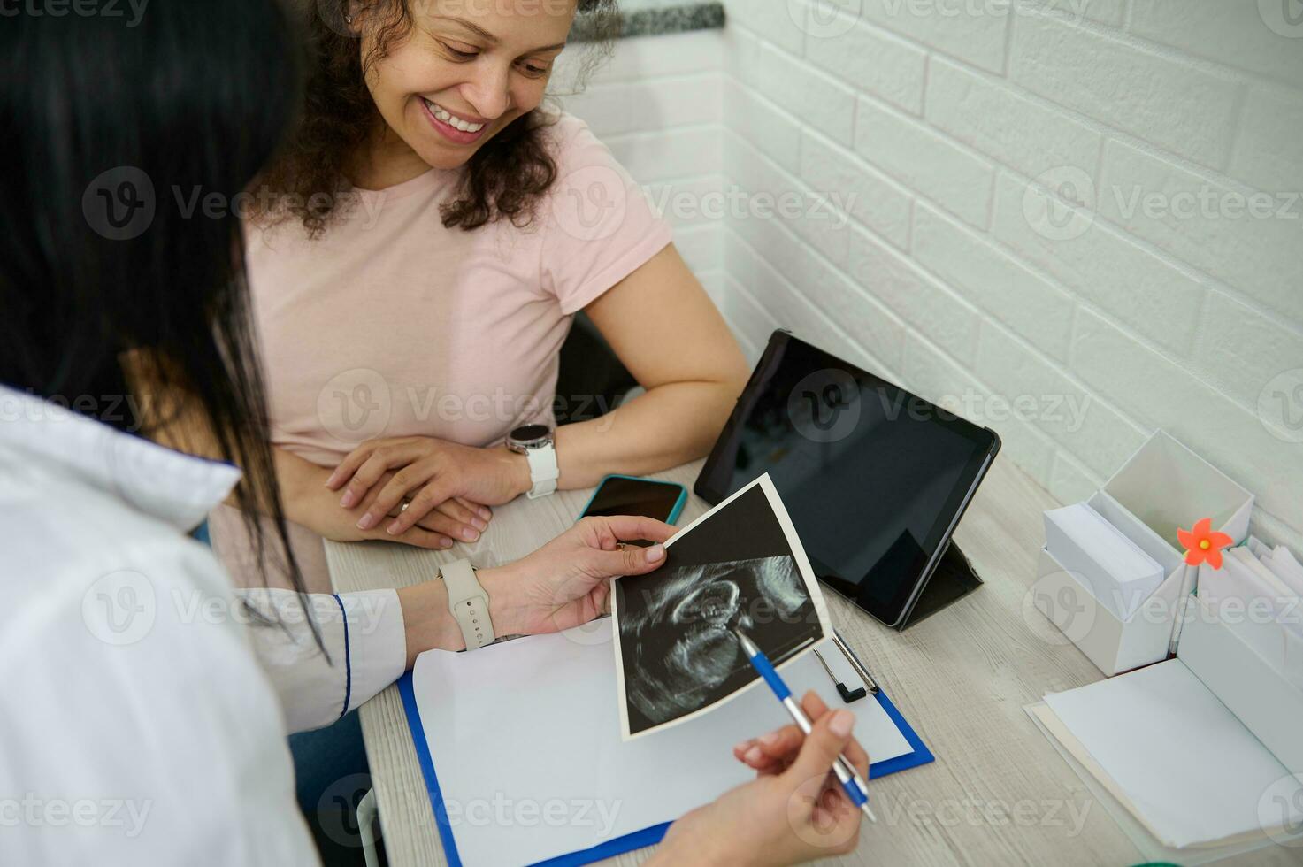 femme médecin obstétricien gynécologue expliquant à une content Enceinte femme le ultrason analyse de sa bébé dans le utérus. photo