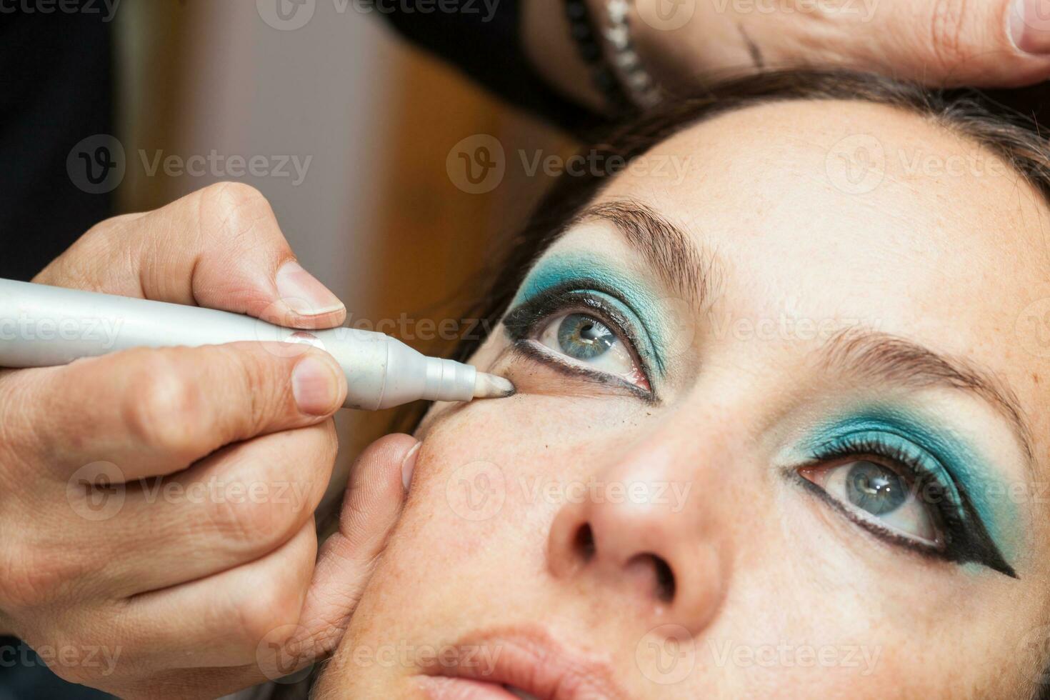 maquillage artiste nettoyage et donnant le final touche à chat yeux maquillage photo