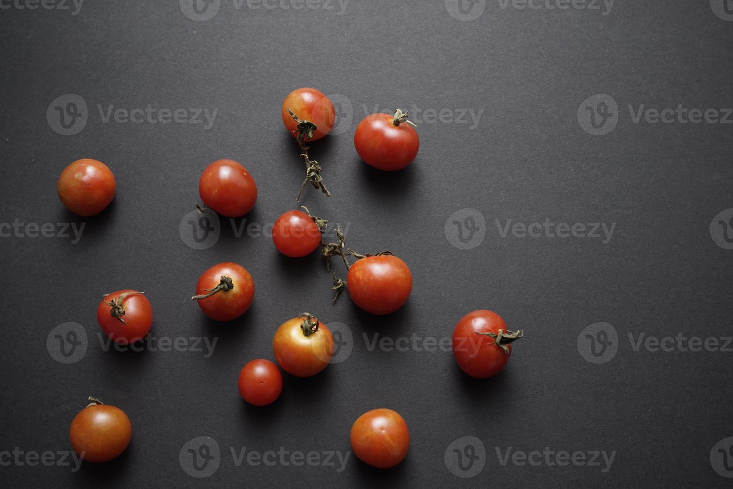 tomates cerises à plat sur fond abstrait texture grunge noir photo
