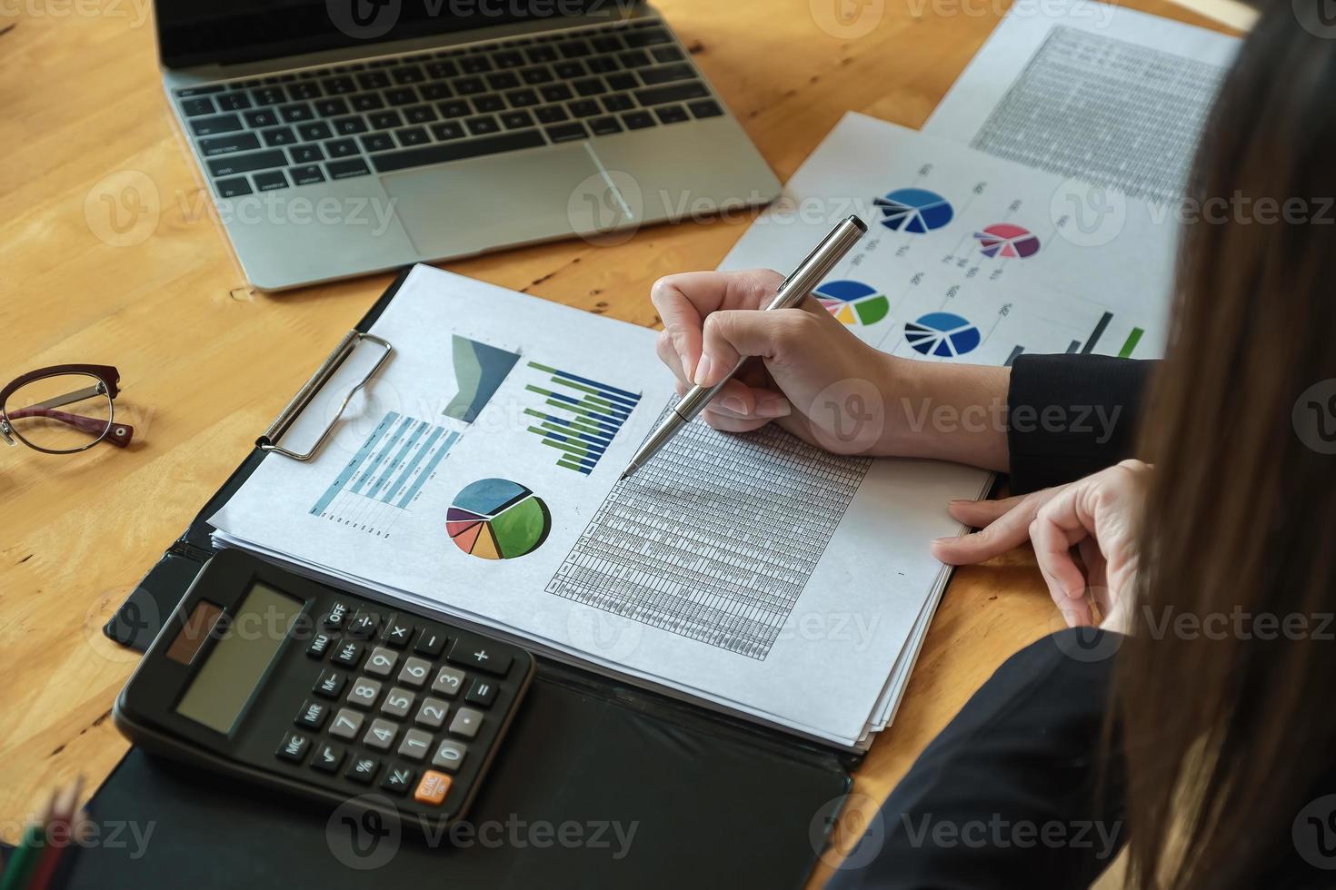 Les femmes d'affaires analysent et vérifient les documents à l'aide d'un ordinateur portable et d'une calculatrice pour calculer les documents budgétaires aux directeurs photo