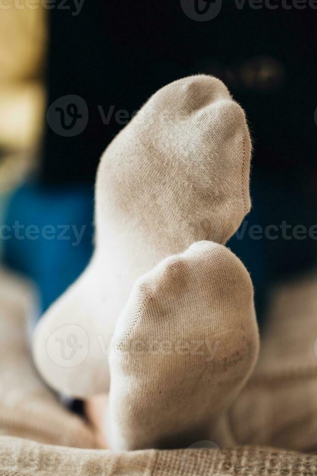 femelle pieds dans blanc sale chaussettes sur lit avec portable - travail de Accueil photo