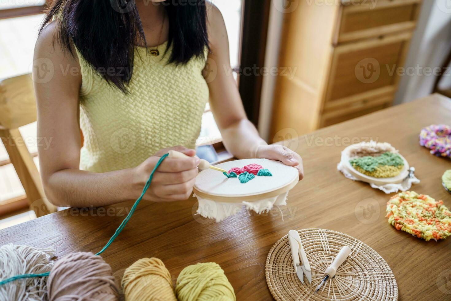 coup de poing aiguille. asiatique femme fabrication Fait main loisir tricot dans studio atelier. designer lieu de travail Fait main artisanat projet DIY broderie concept. photo