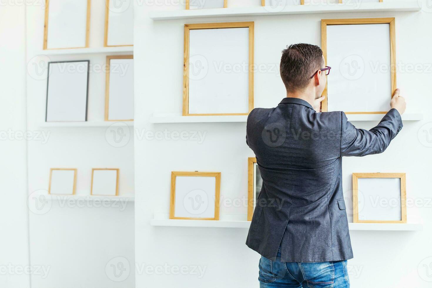 Jeune homme pendaison une Vide affiche dans exposition salle photo