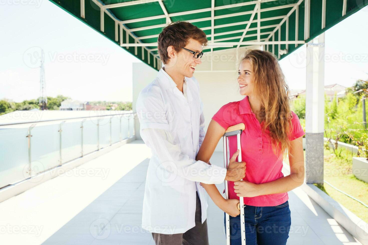 médecin portion femelle patient à faire une premier étape avec le béquille après sérieux jambe blessure photo