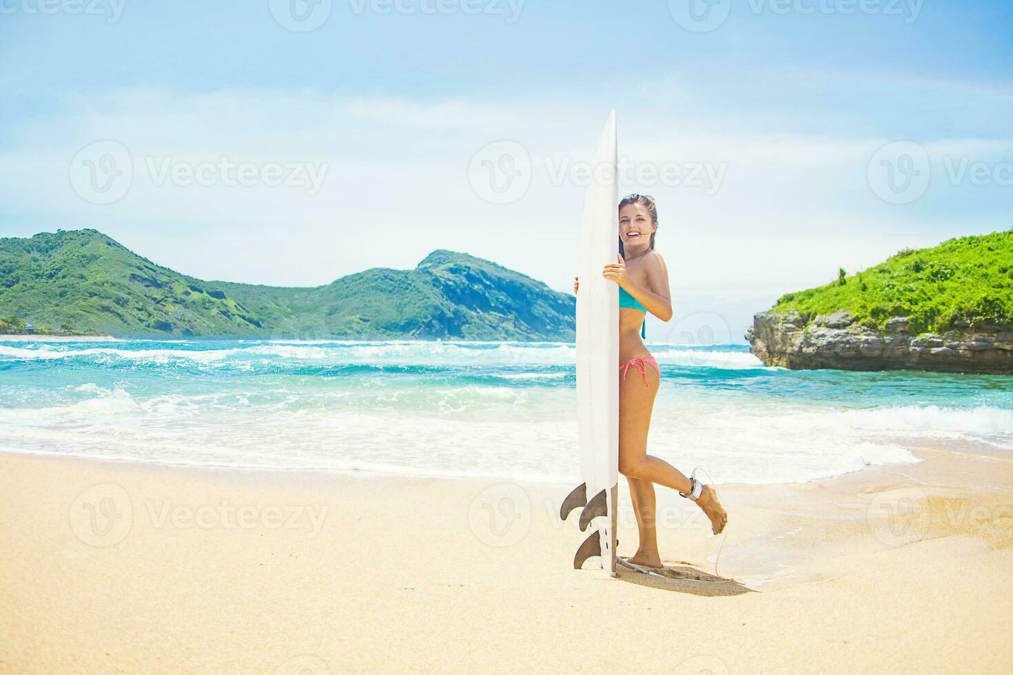 femme dans une maillot de bain repos plus de une le surf sanglier sur une plage dans sumbawa, Indonésie photo