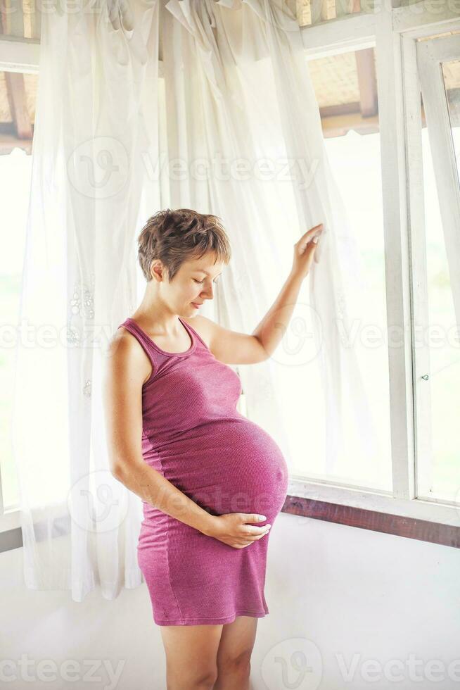 Enceinte femme près le fenêtre à Accueil photo