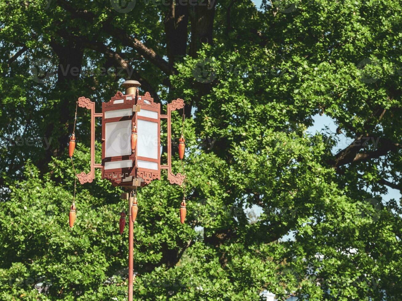 un vieux chinois lanterne sur une vert arbre Contexte photo