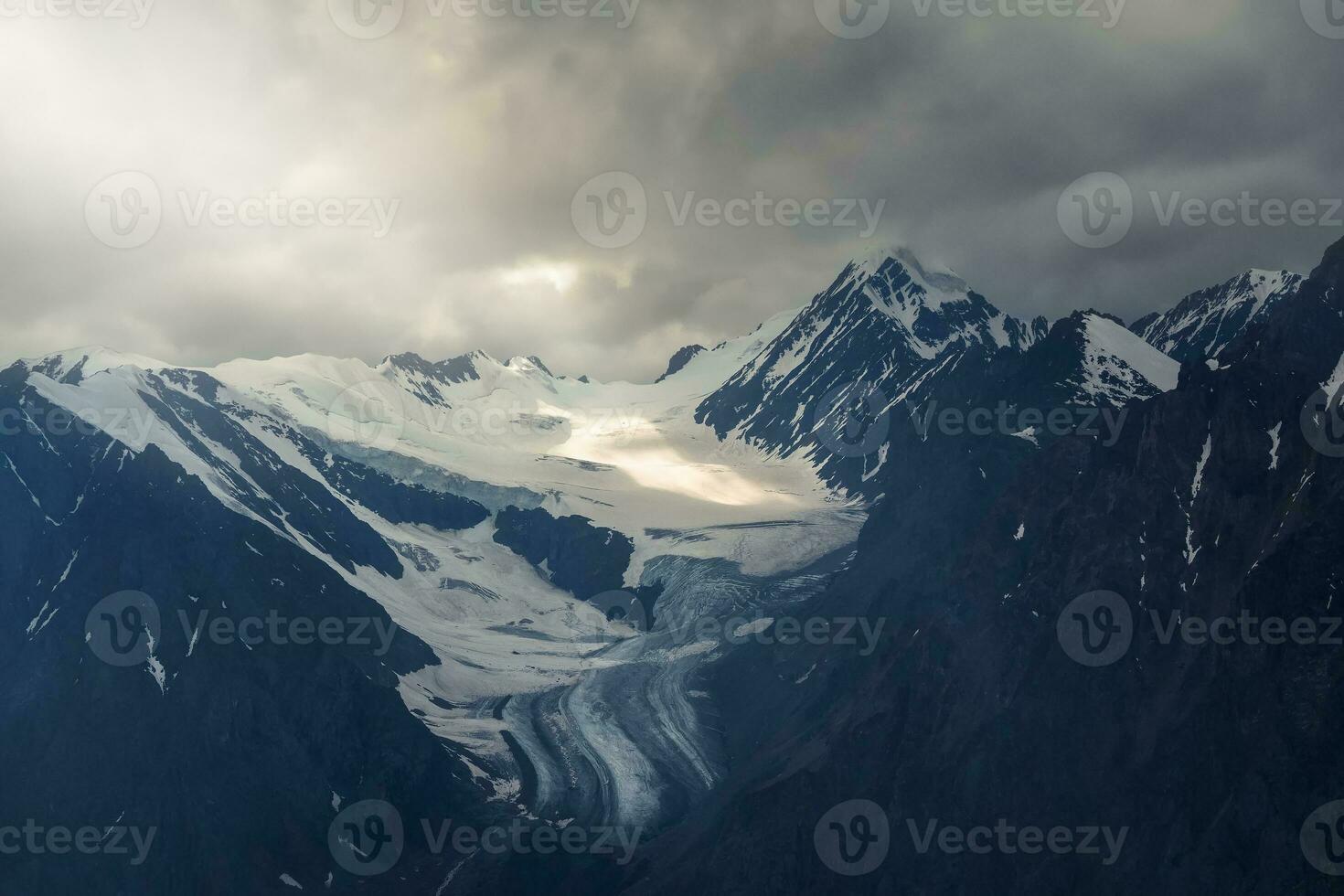 mystique lumière du soleil de paradis dans le foncé Matin montagnes. spectaculaire ciel sur obscurité Montagne pics. mystique glacier Contexte avec spectaculaire montagnes. photo