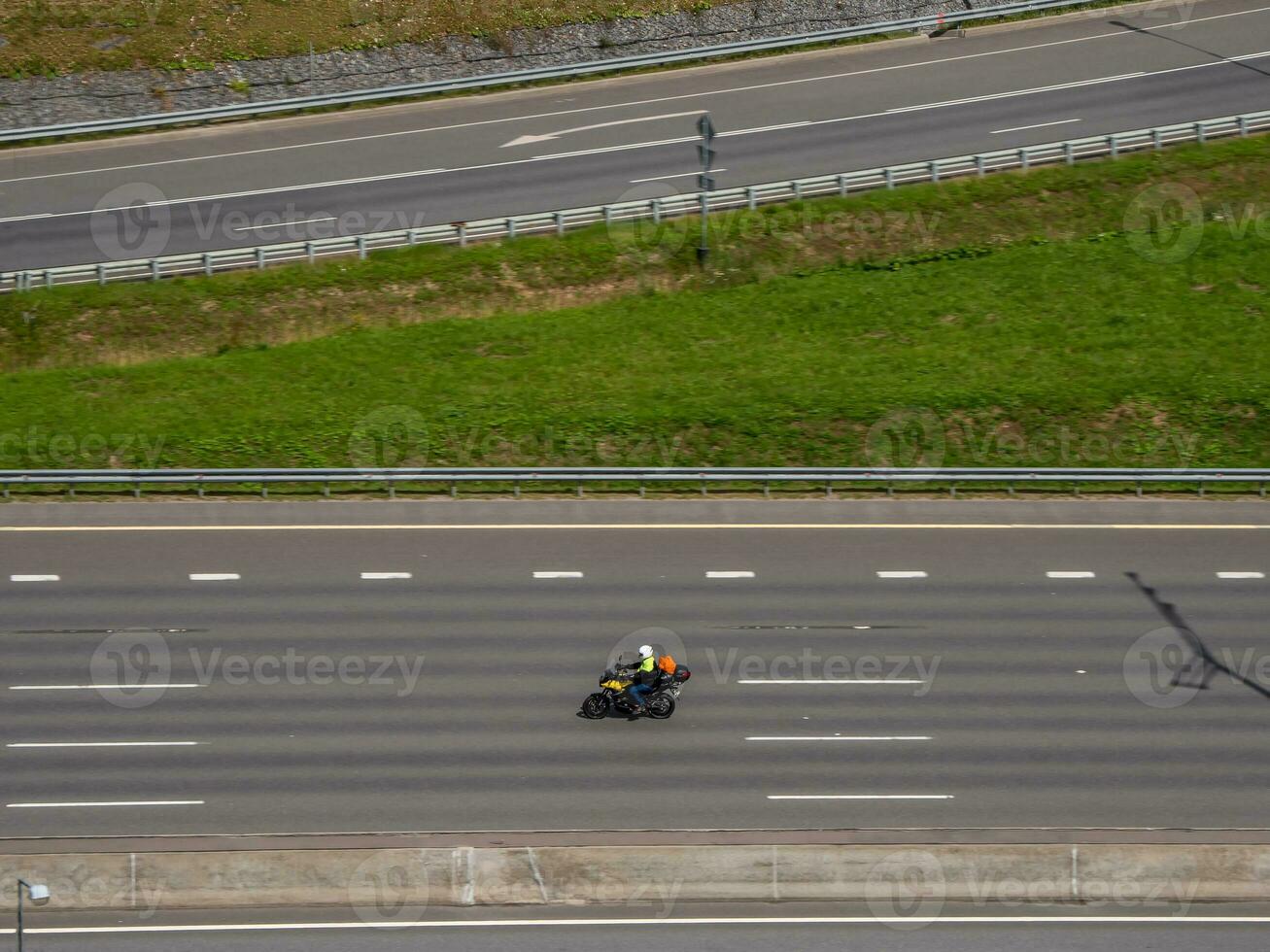 un moto voyageur est courses sur le autoroute, aérien vue photo