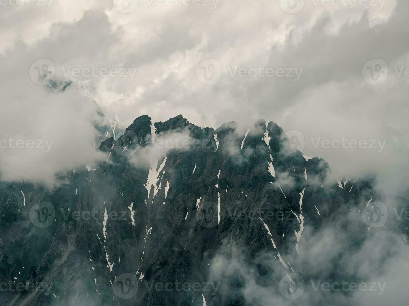 minimaliste Montagne paysage. magnifique minimaliste paysage avec gros neigeux Montagne pics au dessus faible des nuages. atmosphérique minimalisme avec grand neige Montagne hauts dans nuageux ciel. photo