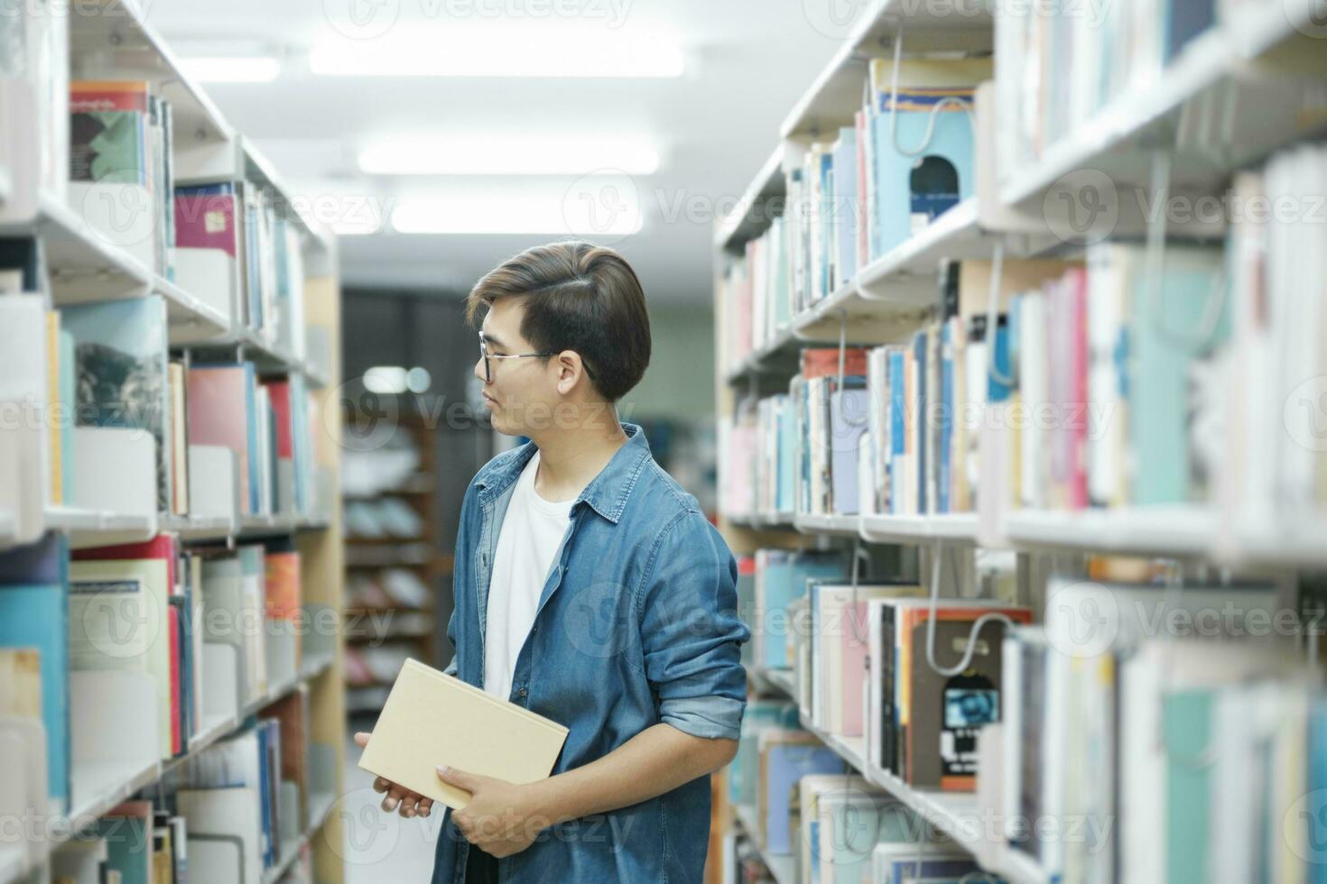 étudiant en train de lire livre à bibliothèque. photo