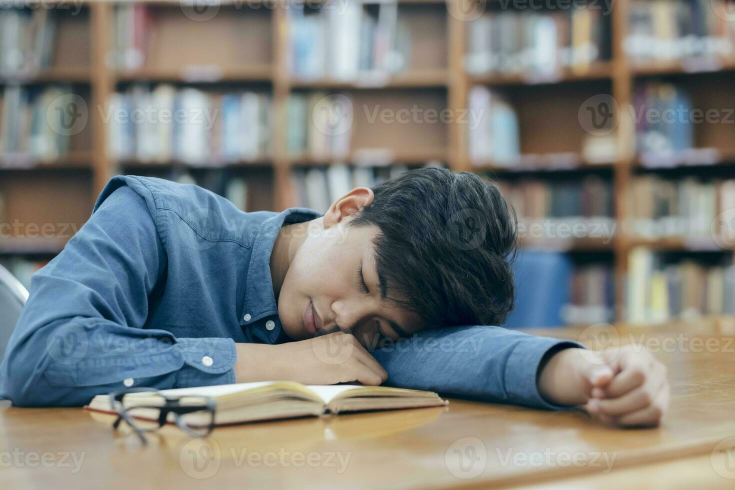 fatigué épuisé étudiant en train de dormir à bibliothèque. photo