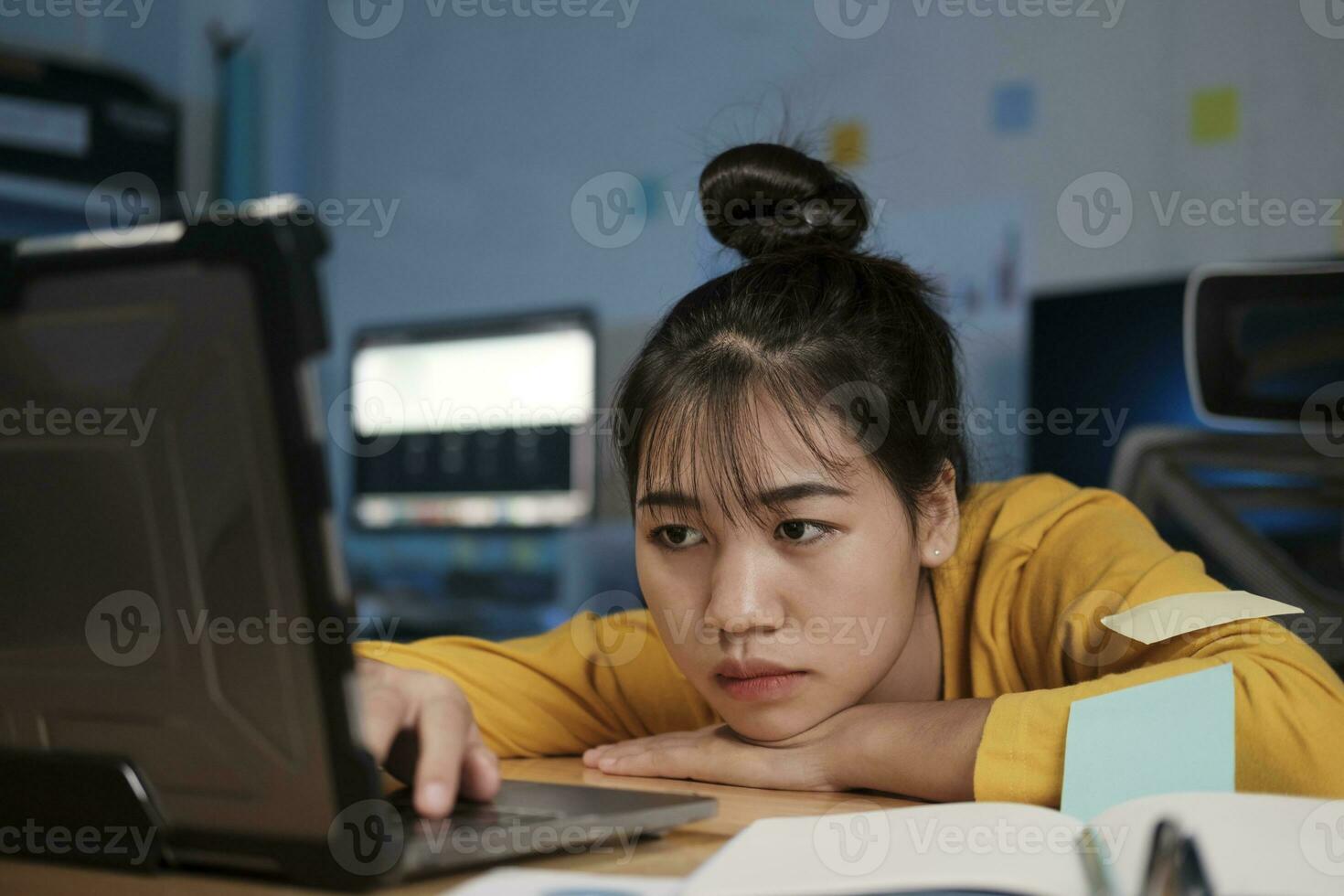 jeune femme travaillant sur un ordinateur portable au bureau photo