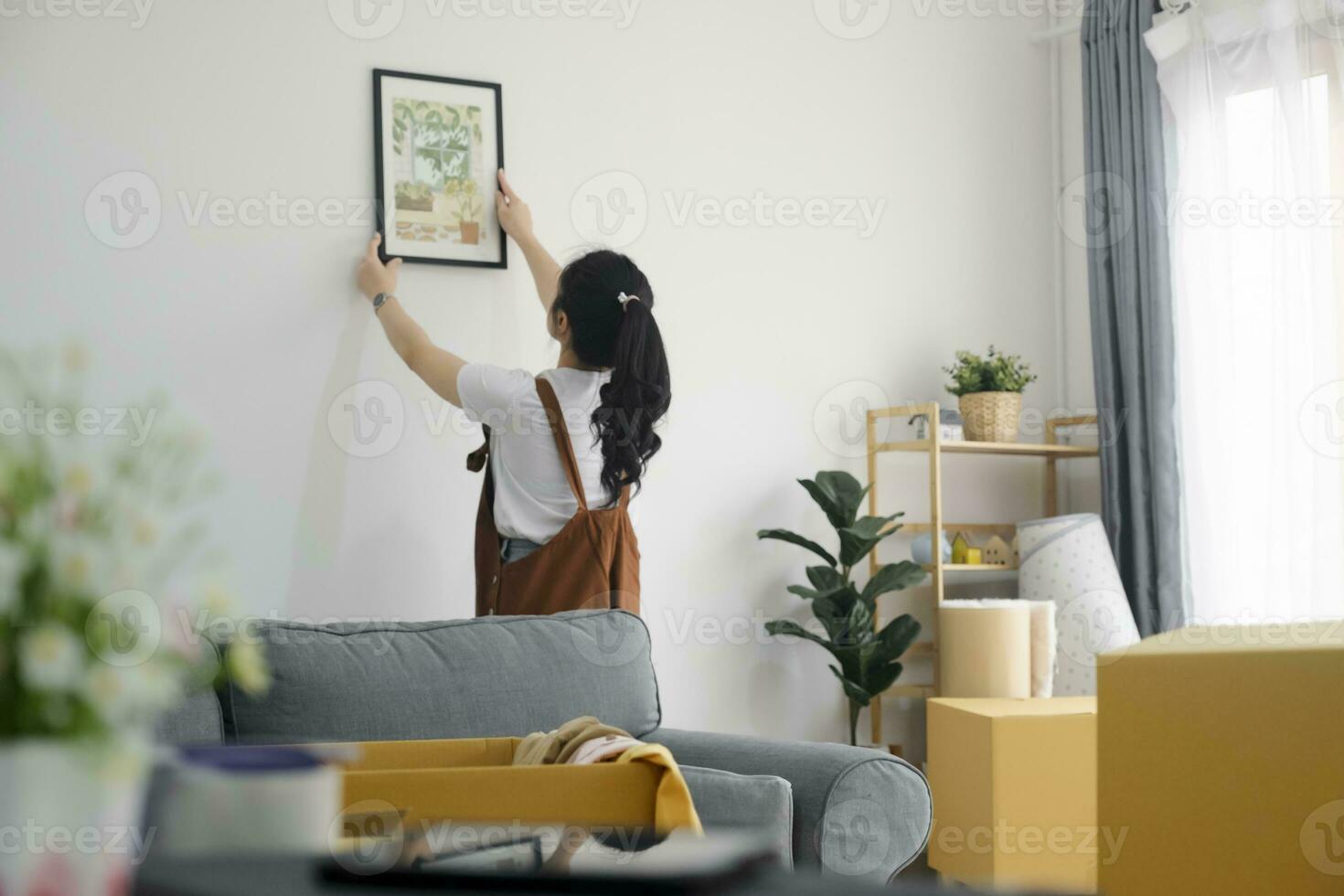 femme décorer Nouveau Accueil tandis que en mouvement dans à Nouveau maison ou appartement. photo