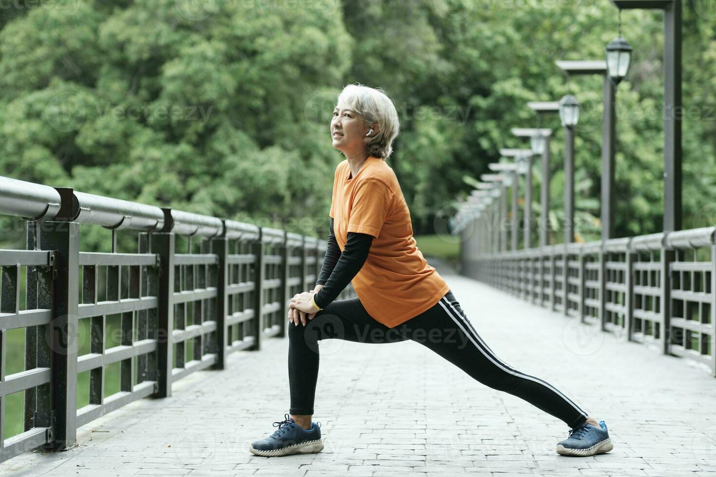 athlétique Sénior femme élongation jambe dans parc. photo