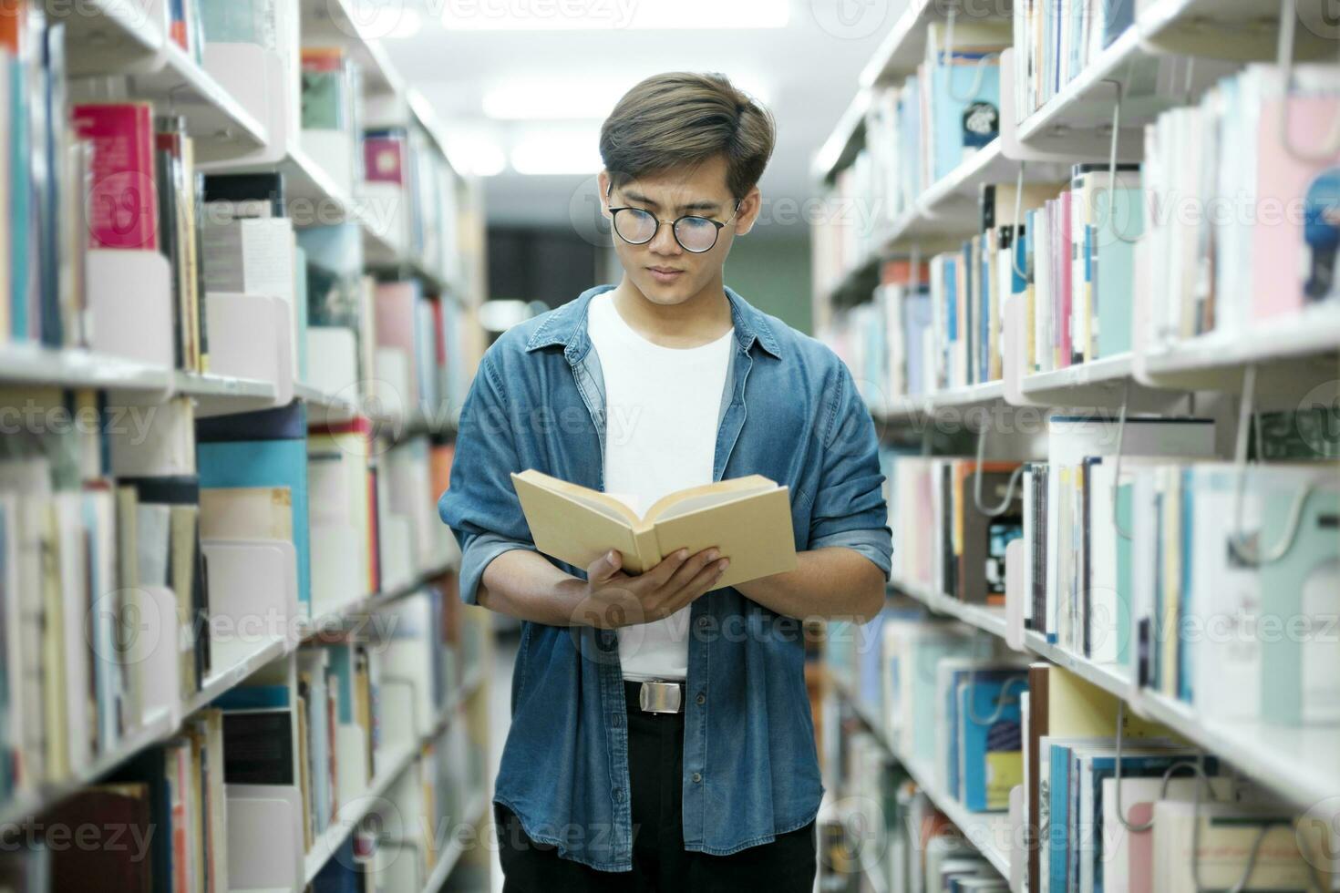 étudiant en train de lire livre à bibliothèque. photo