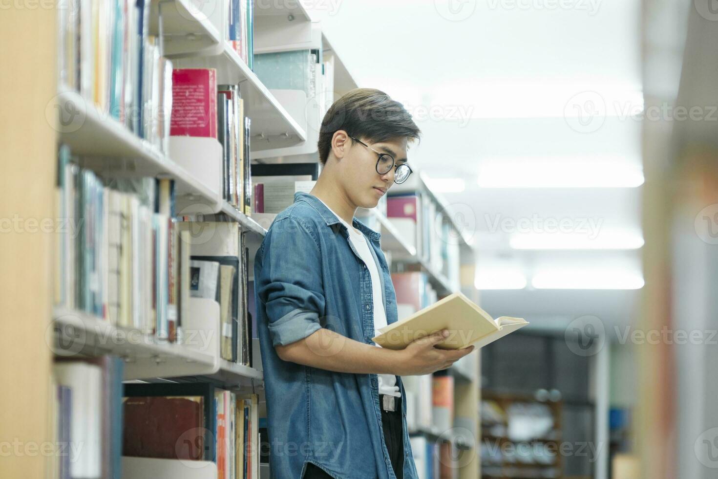 étudiant en train de lire livre à bibliothèque. photo